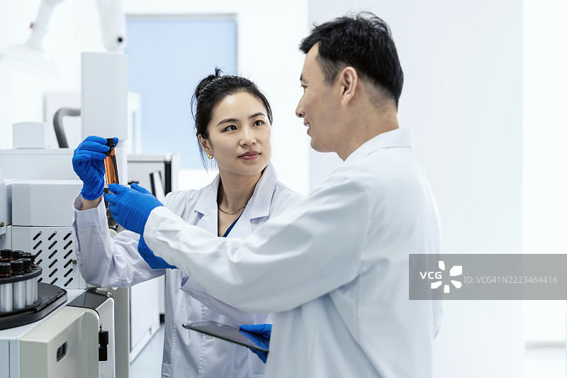 亚洲科学家在实验室讨论实验结果。科学实验室中的研究与开发概念。图片素材