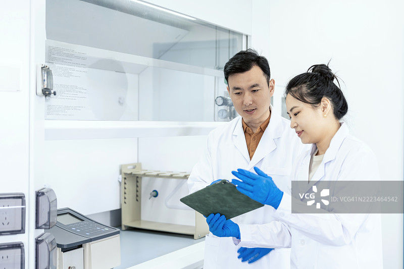 亚洲科学家在实验室讨论实验结果。科学实验室中的研究与开发概念。图片素材
