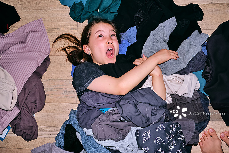 女孩整理她的衣橱，里面有很多东西。图片素材