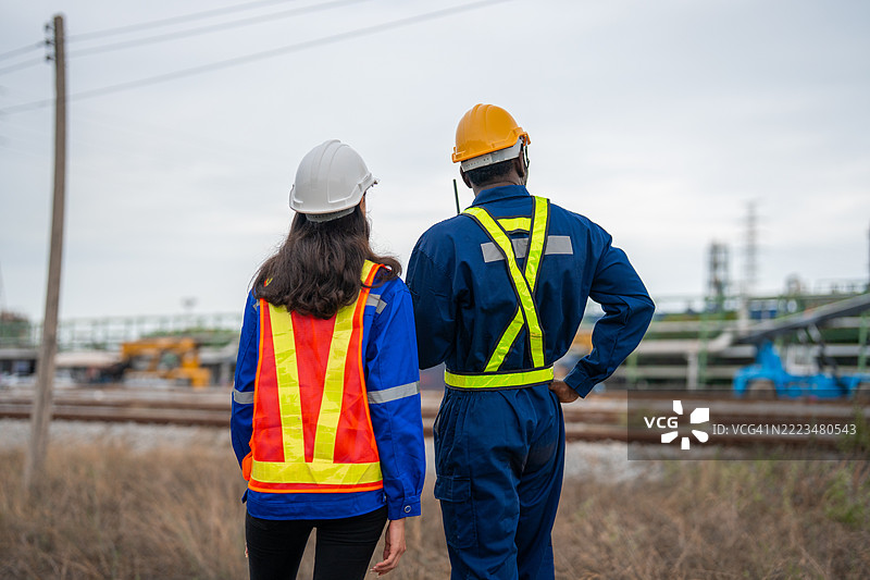 铁路工程师在火车车间散步时讨论工作图片素材