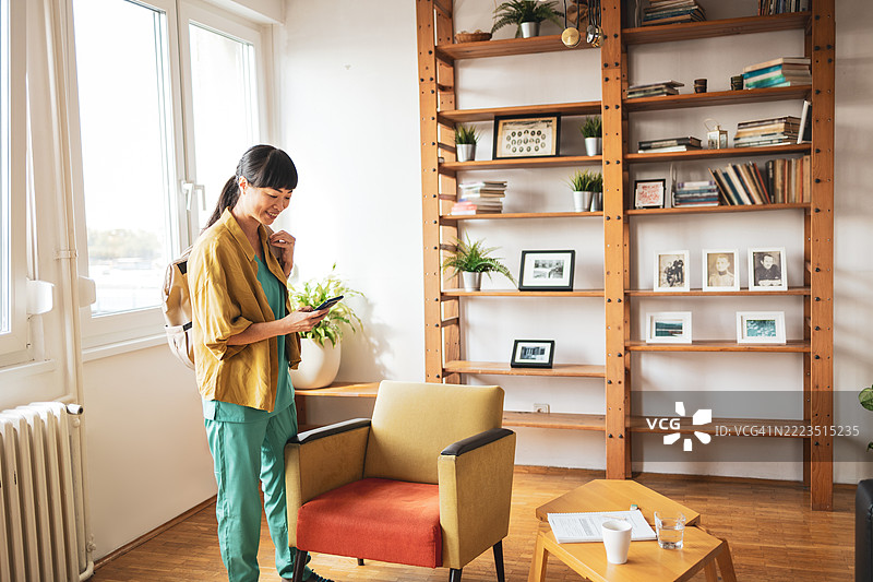 护士在现代公寓下班后查看手机图片素材