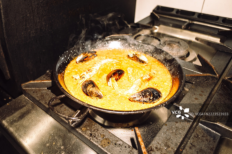 餐厅厨房中，锅里煮着虾和贻贝的海鲜酱汁图片素材