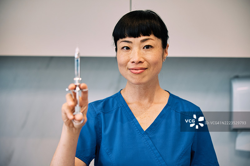 自信的日本女性牙医手持注射器图片素材