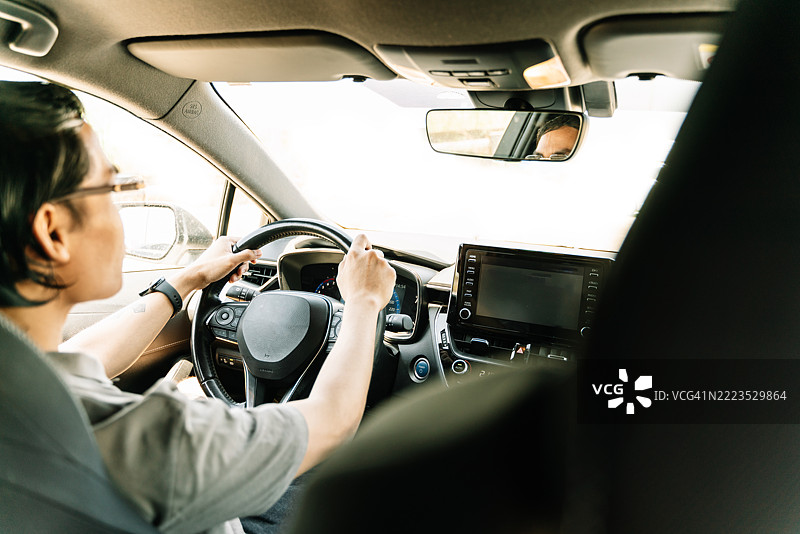 年轻男子在阳光明媚的日子里驾驶现代汽车图片素材