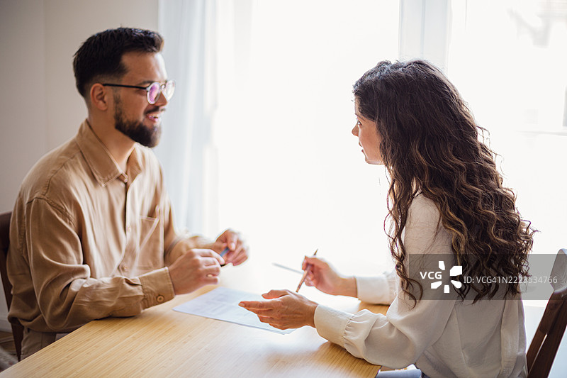 女商人在办公室与男性同事讨论合同条款图片素材