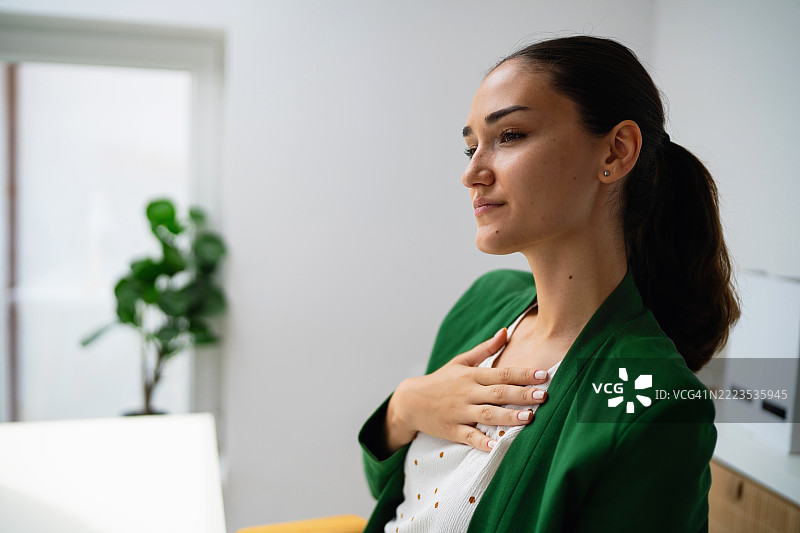 自信的年轻职业女性在现代办公室环境中沉思。图片素材