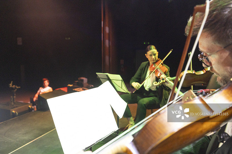 一个弦乐四重奏在舞台上为观众演奏古典音乐会图片素材