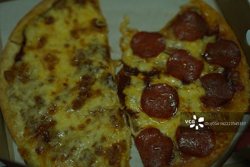 薄脆的意大利香肠披萨，配有奶酪和披萨酱，撒上马苏里拉奶酪图片素材