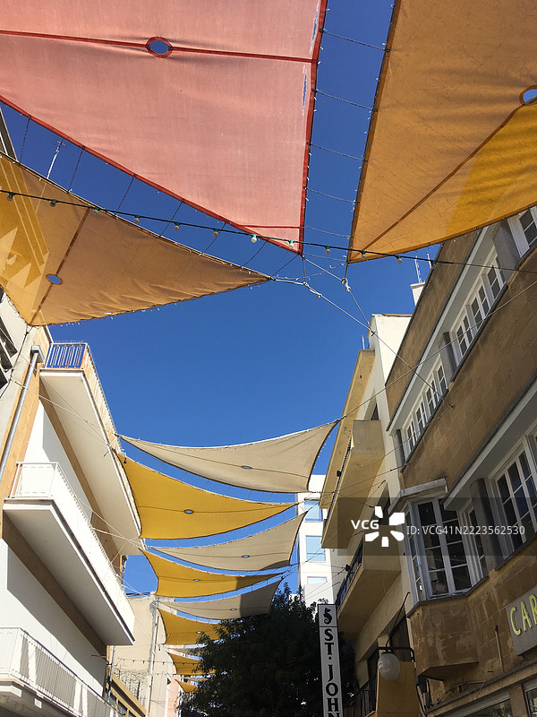 古城街道上五彩斑斓的遮阳篷映衬着蓝天，尼科西亚，塞浦路斯，2019年3月，莱夫科夏图片素材