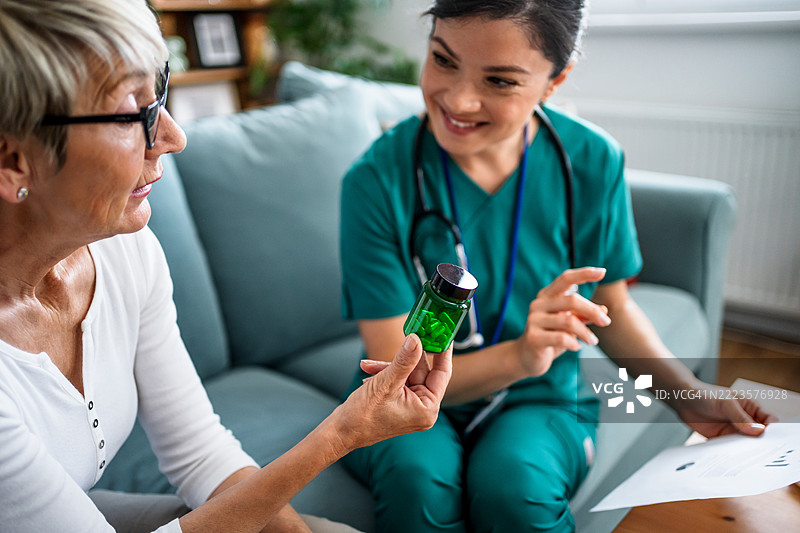 护士在家中向老年患者解释药物剂量图片素材