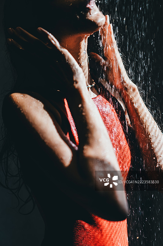 美丽的年轻女性在阳光明媚的浴室里享受温暖的淋浴图片素材