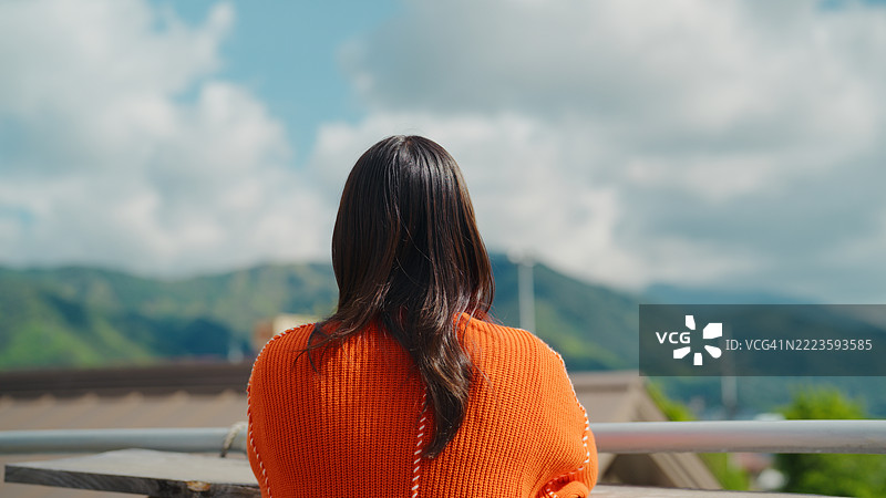女人在屋顶上欣赏自然风光图片素材