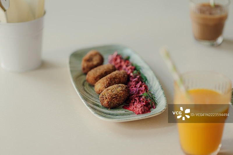 面包屑炸鸡肉丸配甜菜根沙拉和莳萝，盛在盘子里图片素材