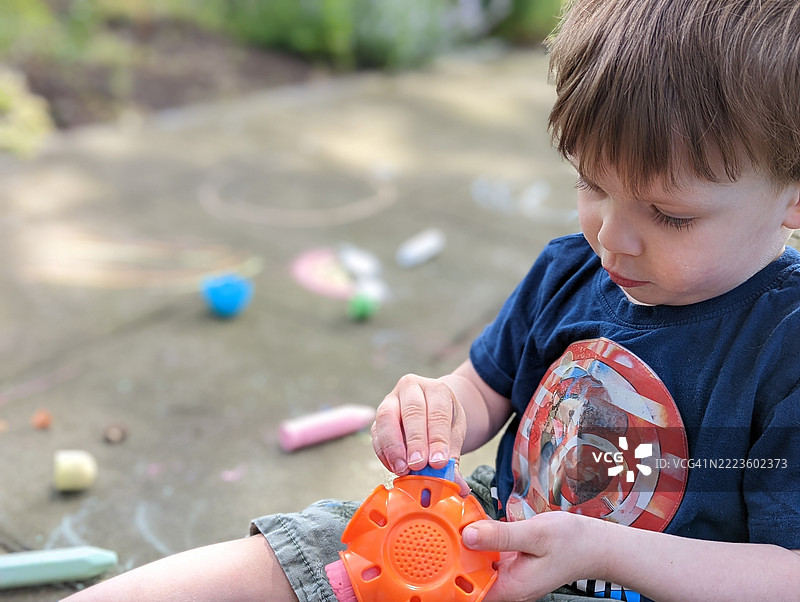 小男孩在玩人行道粉笔图片素材