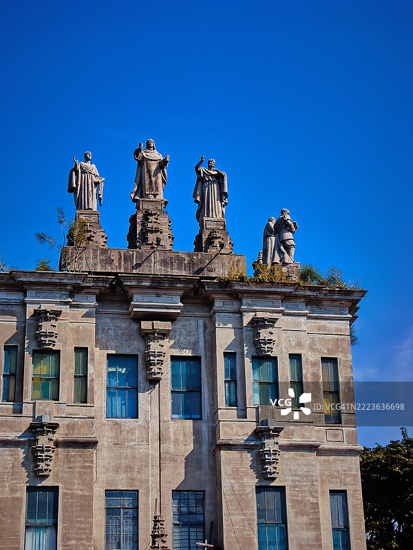 一座古典风格建筑顶部的雕像群，位于菲律宾的圣托马斯大学（UST）。图片素材