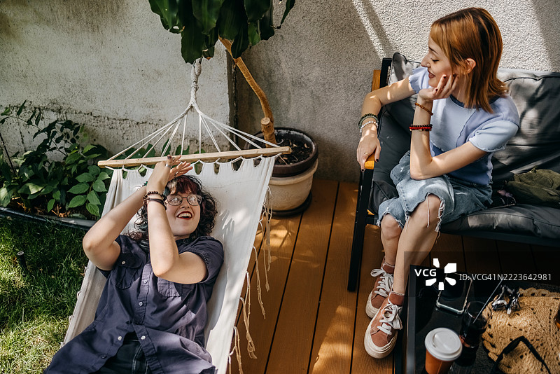 女性朋友们在现代咖啡馆里一边聊天一边享受饮品和放松时光图片素材