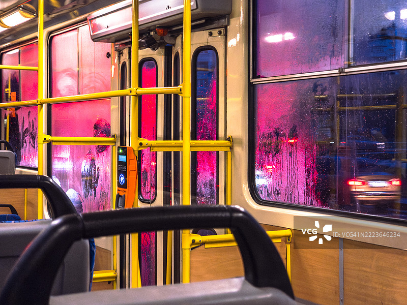 乌克兰夜间公交车内景，窗户上有凝结水珠，外面可见生动的城市灯光。图片素材