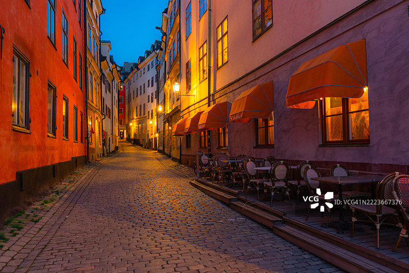 斯德哥尔摩，瑞典黄昏时分的鹅卵石街道与户外餐厅座位图片素材