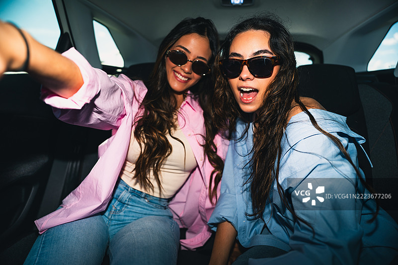 两位年轻女子在车上旅行时自拍图片素材