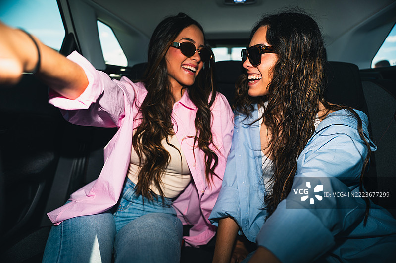 两位年轻女性在汽车后座自拍图片素材