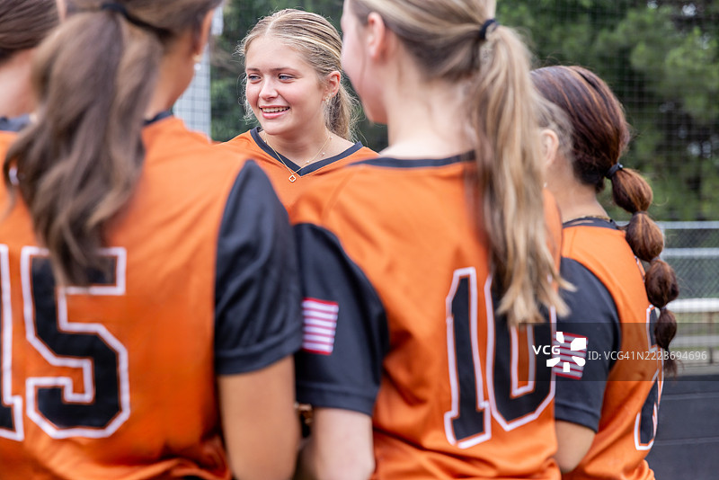 高中软球队在场边聚在一起讨论比赛图片素材