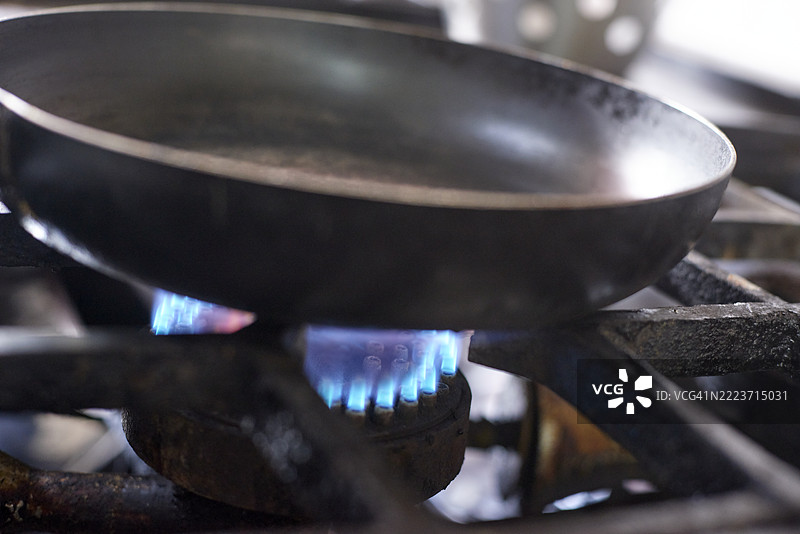 厨房中煤气灶上的煎锅加热中图片素材