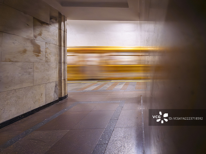 地铁站内部，模糊的列车经过，展示了繁忙日子里城市交通系统的运动和建筑特色。图片素材