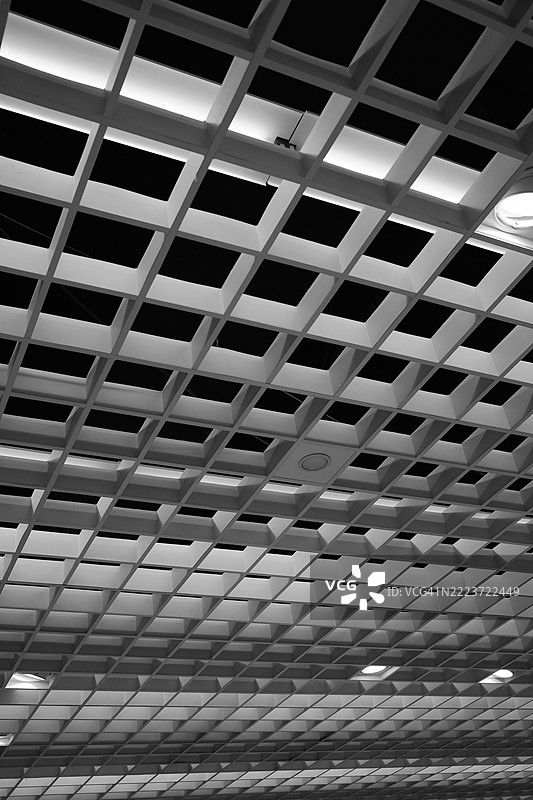 黑白色的几何天花板结构，带有发光的网格图案图片素材