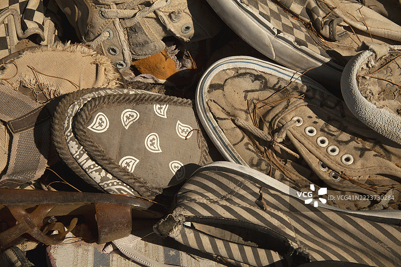 一堆被丢弃的帆布鞋特写。图片素材