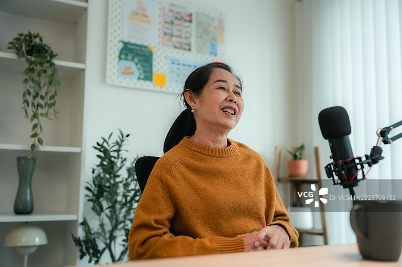 年轻女性正在采访一位年长女性，讨论现代退休生活的播客节目。图片素材