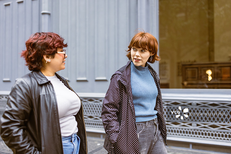 两位女性在城市街道上交谈图片素材