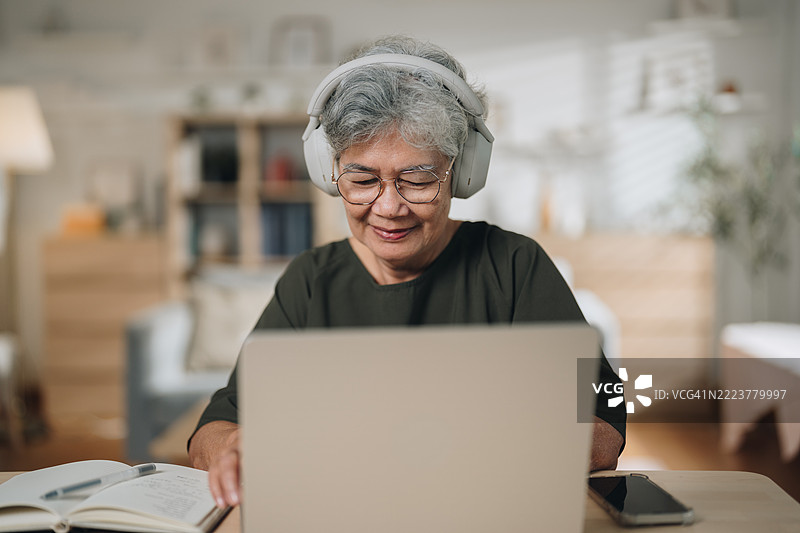一位老年女性在家参加在线语言课程学习外语图片素材