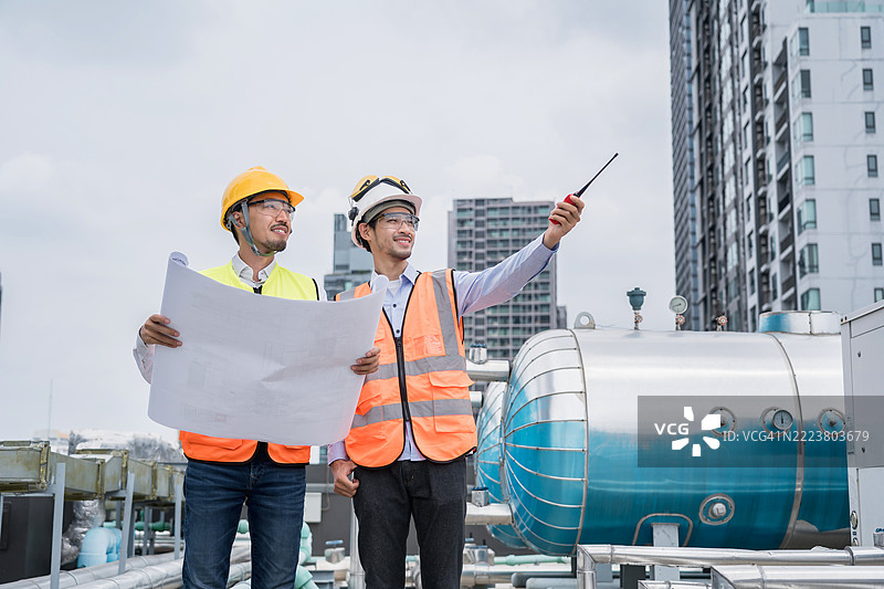 工程师在屋顶上讨论项目并查看蓝图图片素材