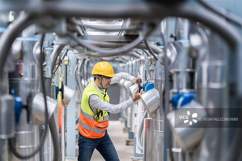 工程师在工厂中调整工业阀门图片素材