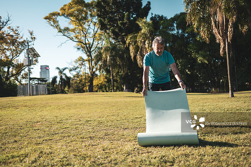 老年人在公园里准备瑜伽垫以进行锻炼图片素材