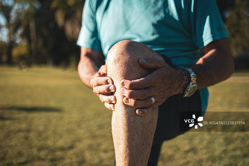 老年人在户外锻炼时感到膝盖疼痛图片素材