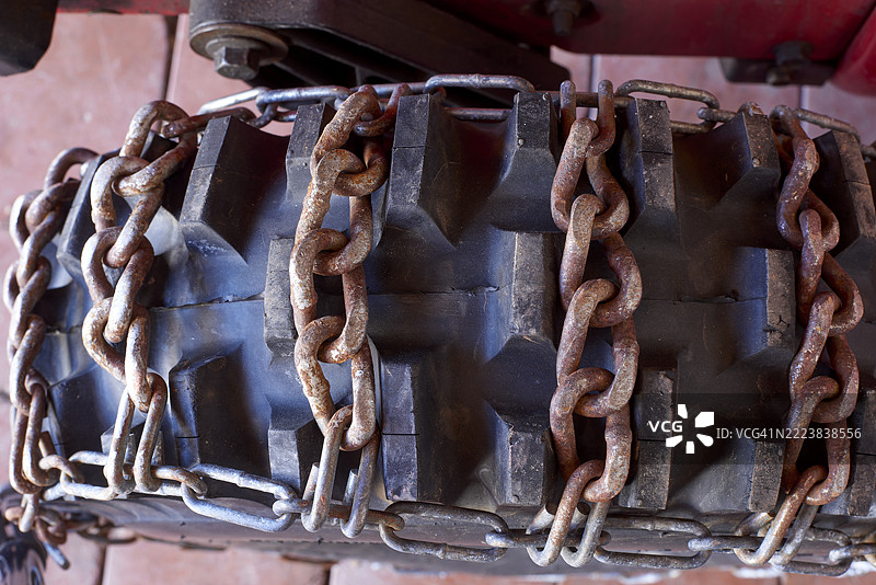 生锈的雪链缠绕在拖拉机轮胎上以增强牵引力图片素材
