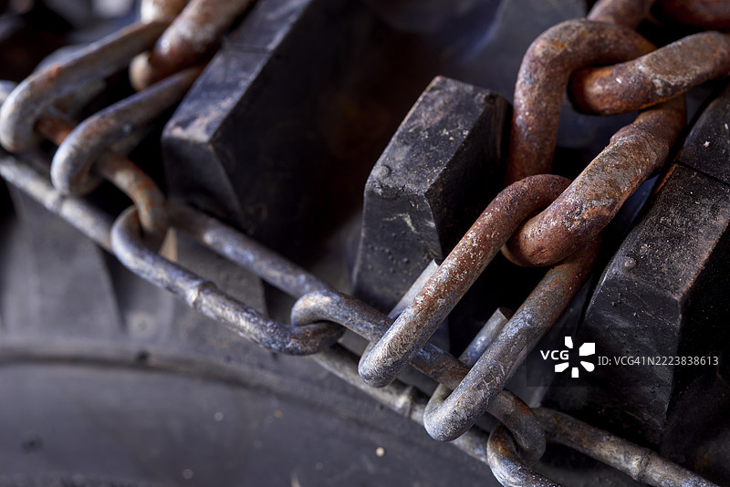 汽车轮胎上的生锈雪链特写，确保安全的冬季驾驶图片素材