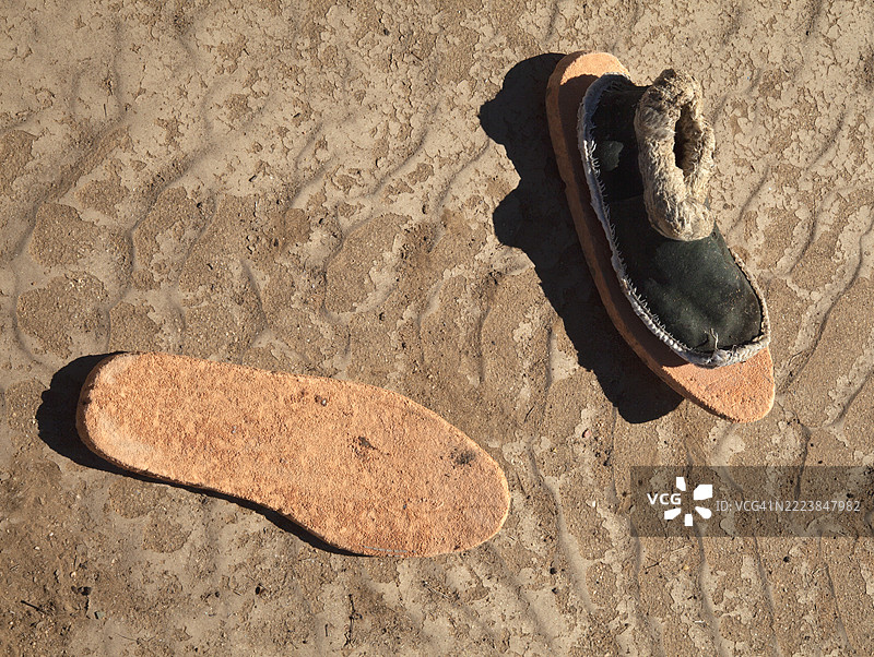 地面上丢弃的一双拖鞋靴。图片素材