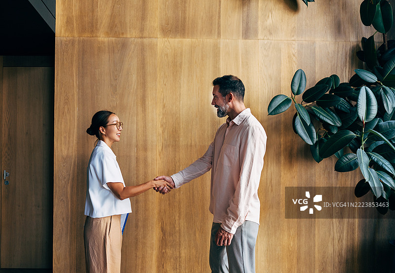 现代办公室环境中的随意商务会议与握手图片素材