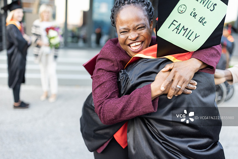 毕业的喜悦：一个拥抱庆祝成就图片素材