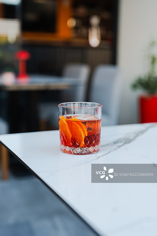 这个男人手里拿着一杯尼格罗尼鸡尾酒。图片素材