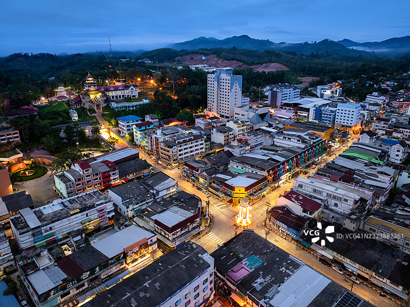 泰国贝通的黎明：城市灯光照亮街道和远处的山脉。图片素材