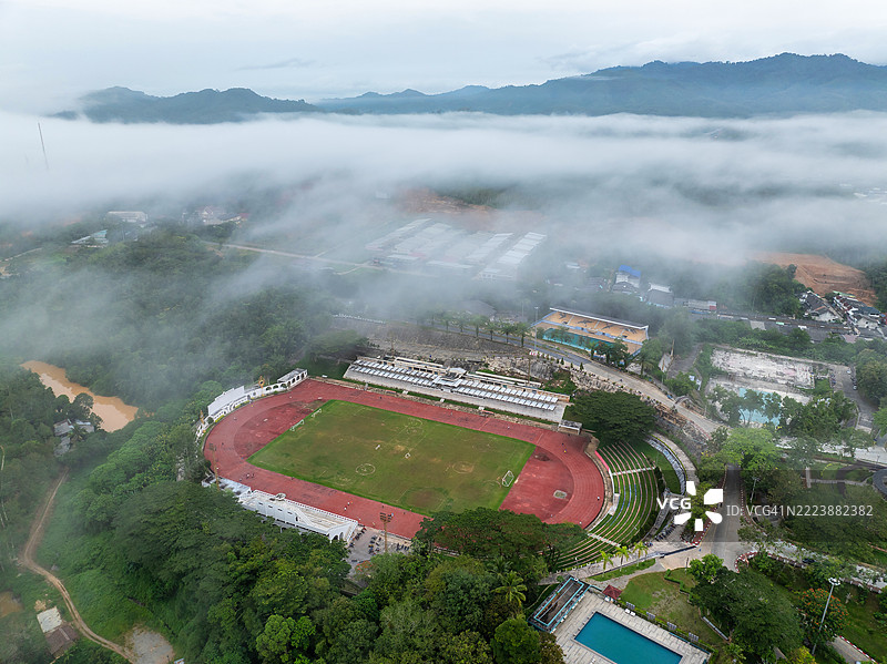 泰国贝通的黎明：城市灯光照亮街道和远处的山脉。图片素材
