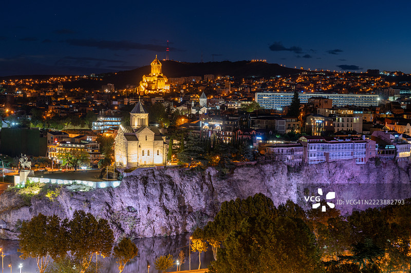 夕阳下的第比利斯老城：城市灯光照亮历史建筑和姆茨赫塔河。图片素材