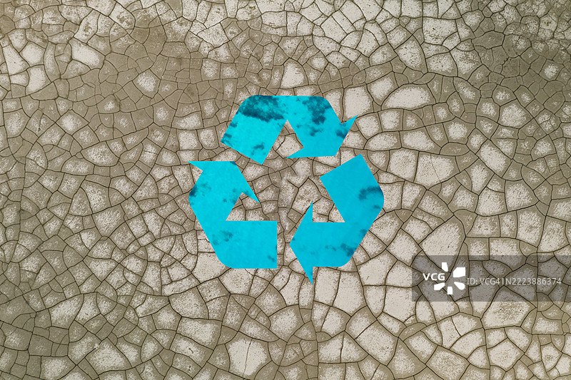 干燥土壤背景上的回收标志与青绿色水域图片素材