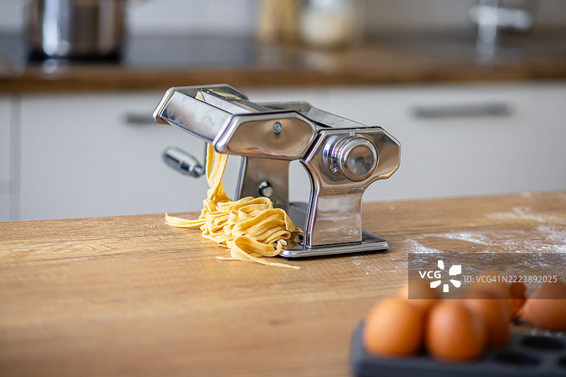 意大利宽面条在意大利面机上被切割的特写镜头图片素材