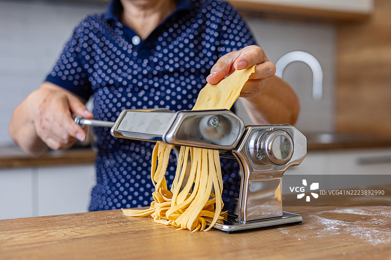 传统意大利面制作，使用手摇面条机图片素材