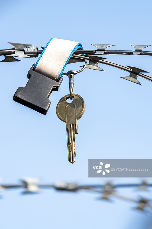 一把钥匙挂在铁丝网上图片素材