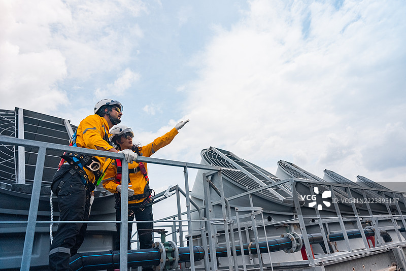 一名工程师正在检查建筑工地上的屋顶太阳能电池板图片素材